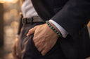Person wearing a dark suit with a EEBracelet African Turquiose green beaded bracelet 