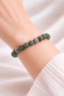 Women hand wearing EEBracelet African Turquiose a green beaded bracelet