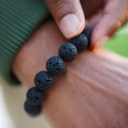 Person holding EEBracelet Black Lava on a blurred background