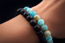 Close-up of a wrist wearing a BlackOnyx and LapisLazuli bracelet with blue and black beads.