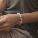 Person wearing EEBracelet Morganite, wearing a gray shirt and beige pants.