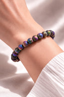 Close-up of a person's wrist wearing EEBracelet Peacock Druzy Agate on a light background