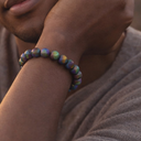 Close-up of a person wearing EEBracelet Peacock Druzy Agate on a blurred background