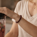 Person holding a blender with a smoothie inside, wearing EEBracelet Red Tiger's Eye 