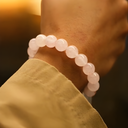 Close-up of a wrist wearing EEBracelet Rose Quartz with a blurred background