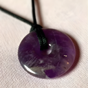 EEMedallion Amethyst on a black cord against a light background