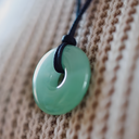 EEMedallion Aventurine on a black cord against a woven background