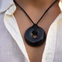 EEMedallion Black Obsidian on a person wearing a white shirt.
