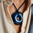 EEMedallion Hawk Eye on a person's neck with a neutral background