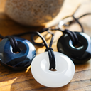 EEMedallion Hawk Eye, White Jade, and Black Obsidian on a wooden surface