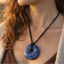 Woman wearing EEMedallion Lapis Lazuli against a blurred natural background
