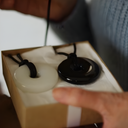 EEMedallion White Jade and Black Obsidian in a box with a hand touching the box.

