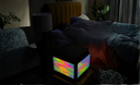 EEQube on a table in a dimly lit room with a couch and lamp in the background.